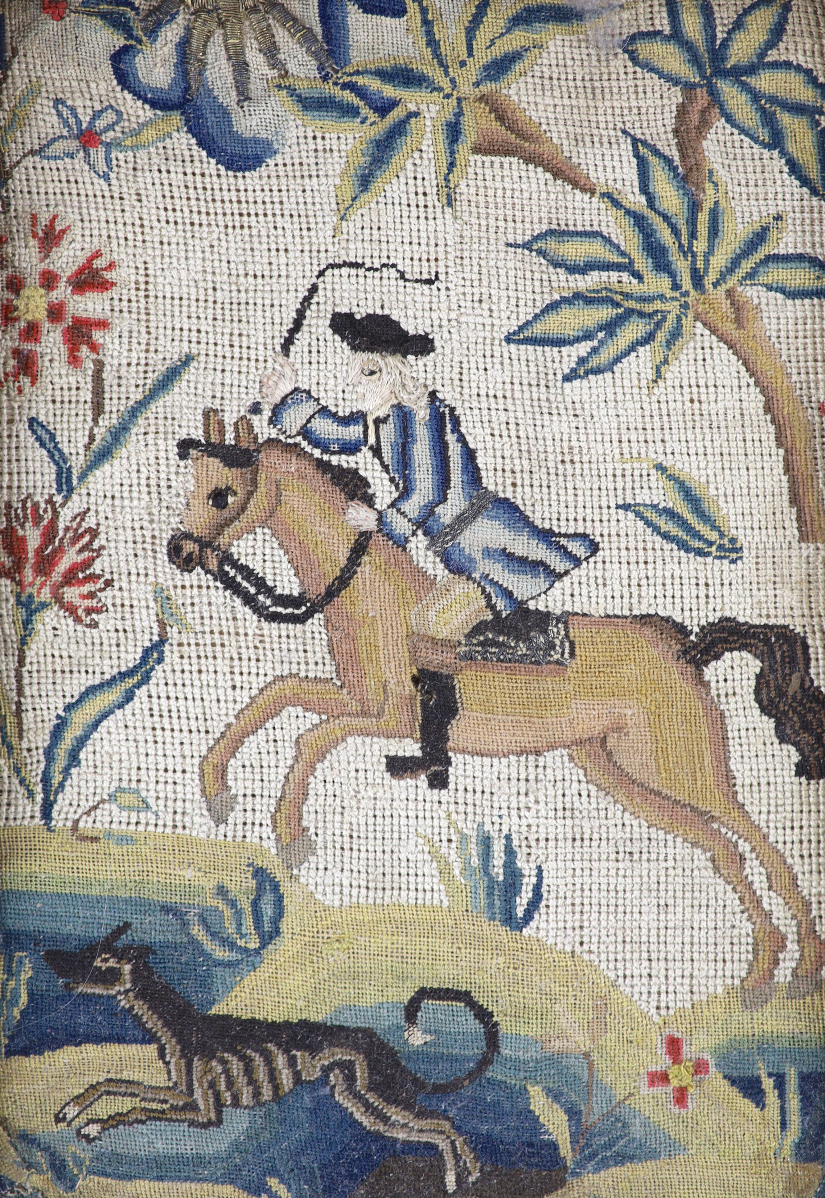 A pair of framed early 18th century needlework panels of a lady and gentleman on horseback with dogs running at their feet 23x16cm excl frame